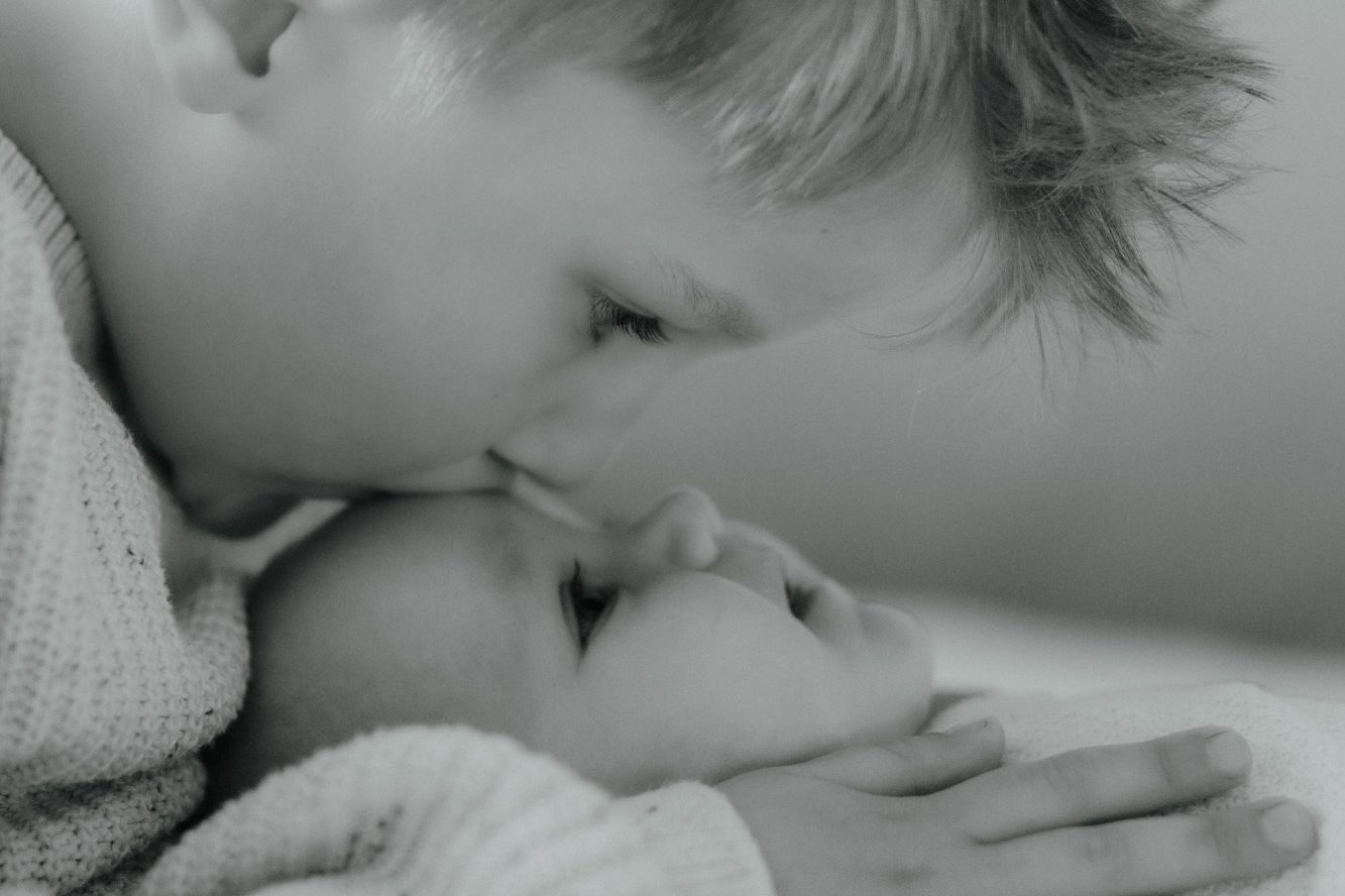 Eine Mutter hält ihr Baby sanft und liebevoll in ihren Armen.