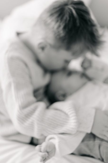 Eine Mutter umarmt ihr neugeborenes Baby in einem liebevollen Moment.